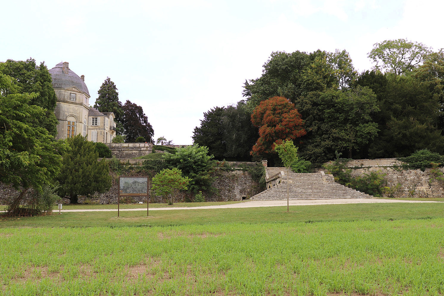 Aménagement paysager patrimonial avec vue panoramique sur vestige historique disparu