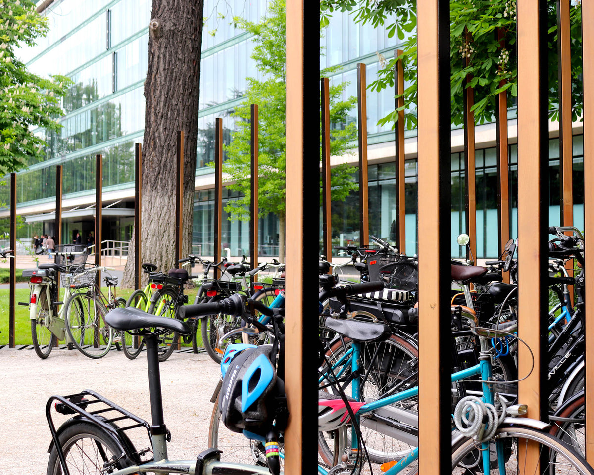 Détail d'un dépose-vélo en IPN et bois, socle métal encastré maintenant la roue