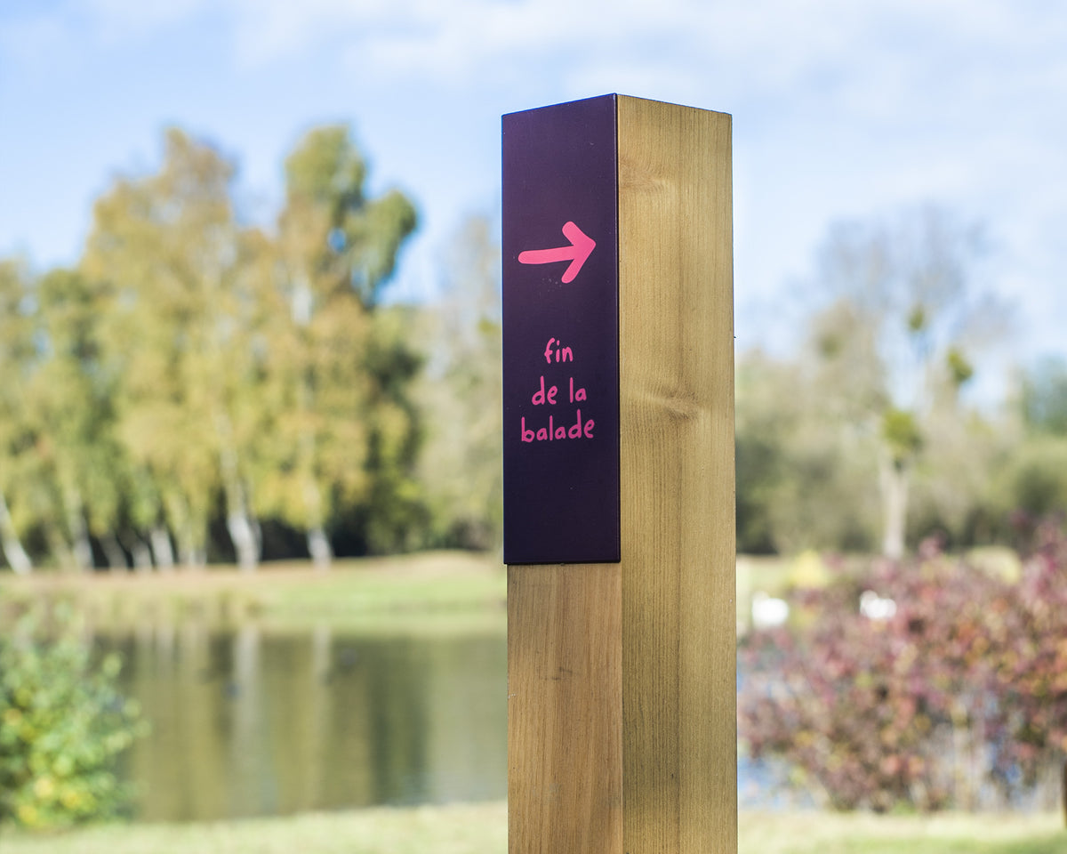 Détail d'un petit mât de jalonnement pédestre en bois et métal, indiquant la fin de la balade