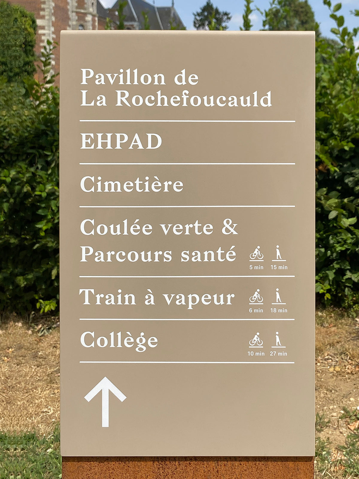 Détail d'un jalonnement piéton et vélo indiquant le temps de parcours pour chaque mobilité