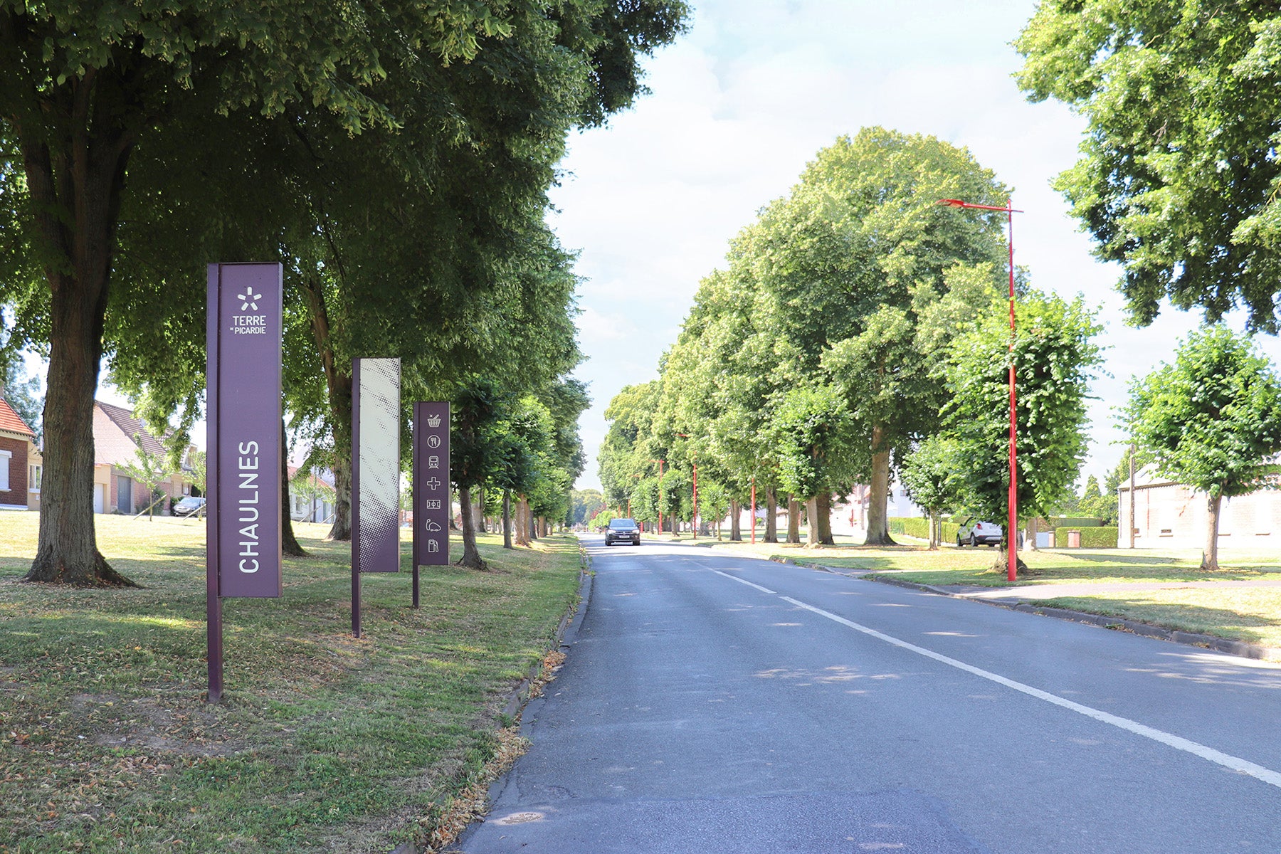 Drapeaux d’entrée de ville en triptyque avec des pictogrammes représentant les attraits de la commune