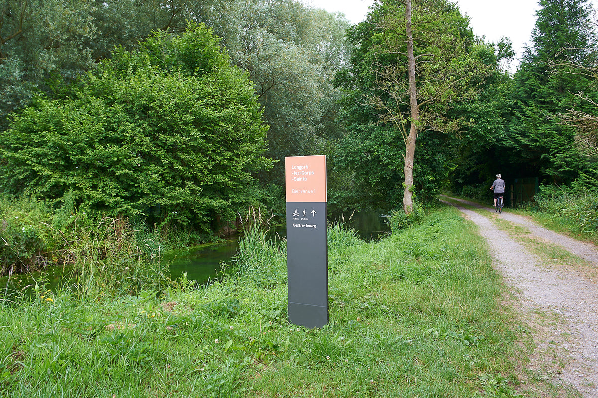 Totem d'orientation pour flux touristiques reconnectant la véloroute au centre commerçant
