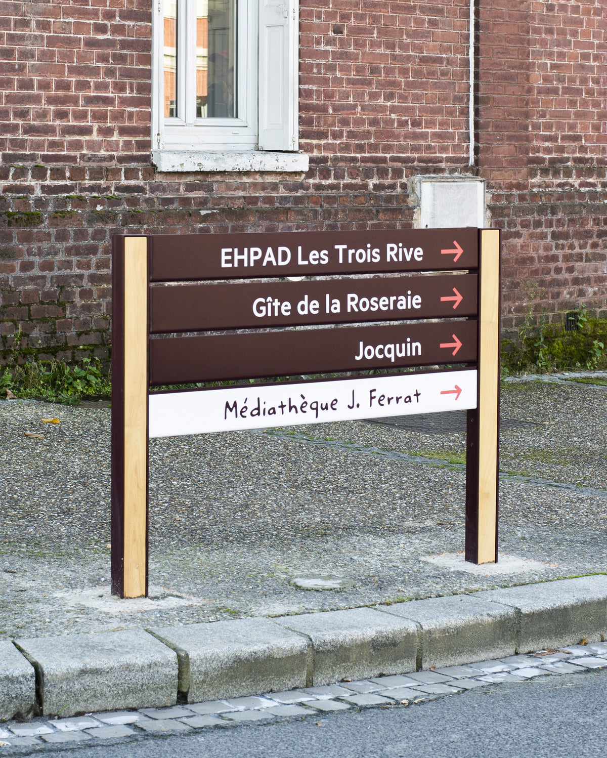 Vue sur une signalétique communale en bois et métal thermolaqué